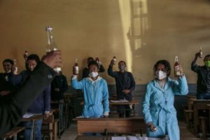 Des lycéens posent avec une bouteille de Covid Organics au lycée J.J. Rabearivelo d'Antananarivo, le 23 avril 2020